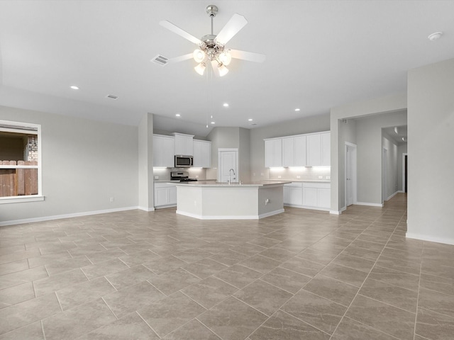 unfurnished living room with ceiling fan and sink