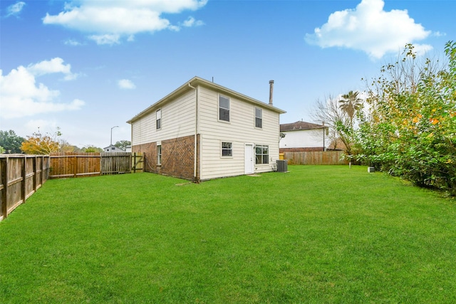 rear view of property with a lawn and cooling unit