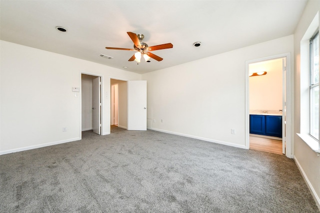 unfurnished bedroom with carpet, ceiling fan, and ensuite bath