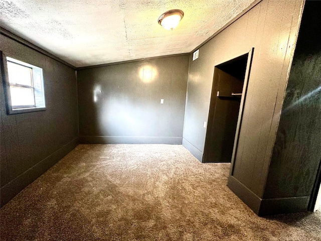 carpeted spare room with a textured ceiling