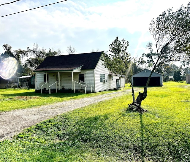 view of front of home featuring an outbuilding, a garage, and a front lawn