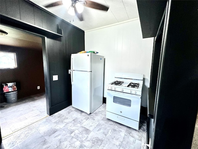 kitchen with white appliances, ceiling fan, and wooden walls