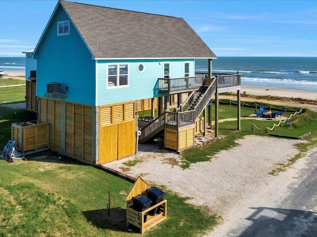 back of property with a beach view, a deck with water view, and central air condition unit