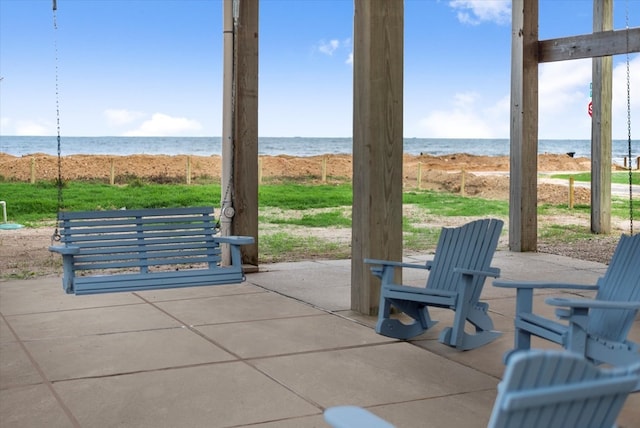 view of patio / terrace with a water view and a beach view