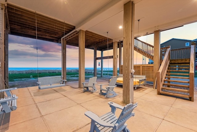 patio terrace at dusk featuring a water view