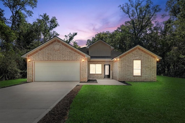 view of front of home featuring a lawn and a garage