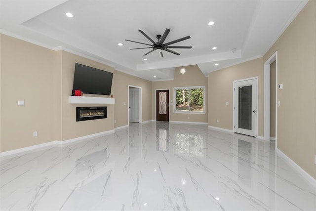 unfurnished living room featuring a tray ceiling, ceiling fan, and crown molding