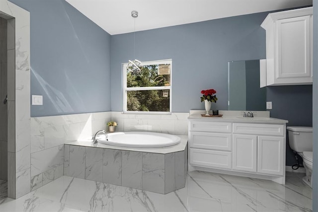 bathroom featuring vanity, toilet, and tiled tub