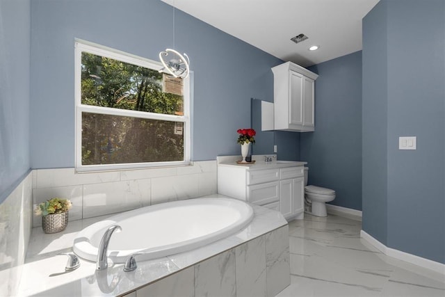 bathroom with vanity, a relaxing tiled tub, and toilet