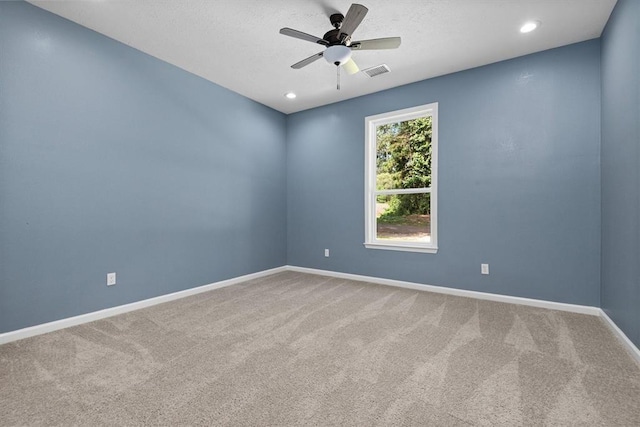 carpeted spare room with ceiling fan