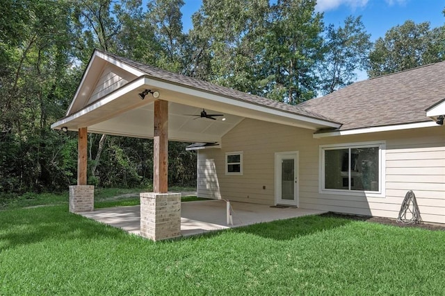 rear view of house featuring ceiling fan, a yard, and a patio