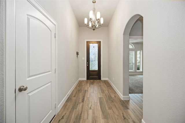 entryway featuring an inviting chandelier and hardwood / wood-style flooring