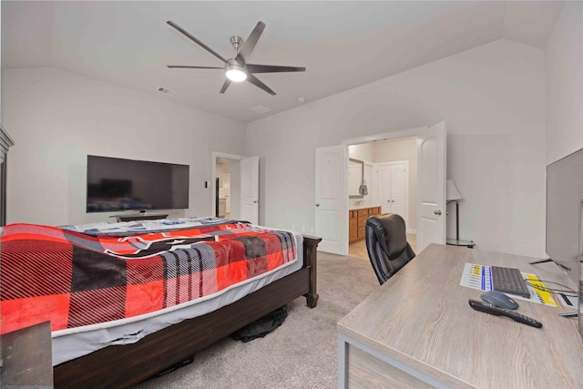 carpeted bedroom featuring ceiling fan, vaulted ceiling, and ensuite bath