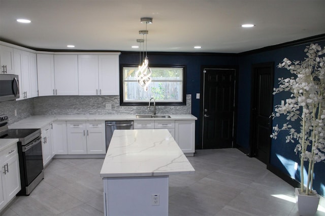 kitchen featuring pendant lighting, a center island, sink, appliances with stainless steel finishes, and white cabinets