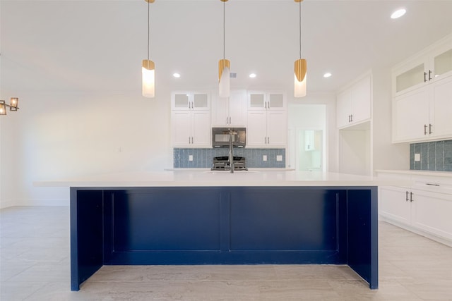 kitchen with a center island with sink, decorative light fixtures, white cabinetry, and range