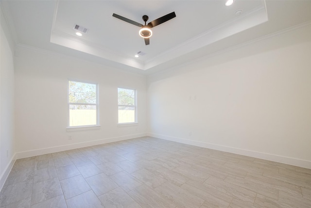 unfurnished room with a raised ceiling, ceiling fan, and crown molding