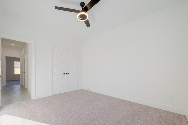 unfurnished room with ceiling fan and light carpet