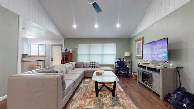 living room featuring ceiling fan, dark hardwood / wood-style floors, and vaulted ceiling