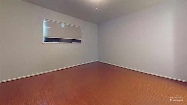 unfurnished room featuring hardwood / wood-style flooring and a textured ceiling