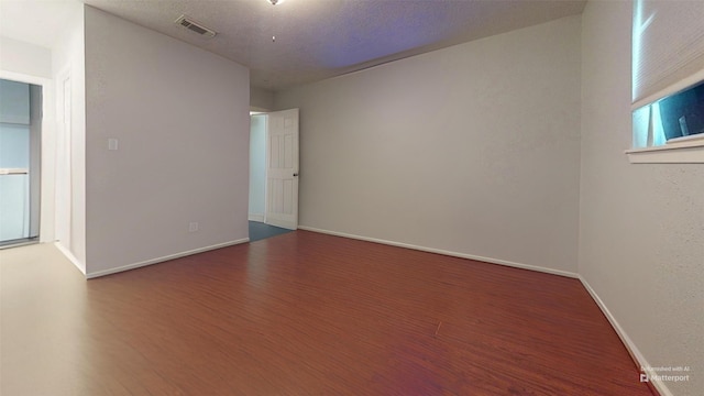 spare room with hardwood / wood-style floors and a textured ceiling