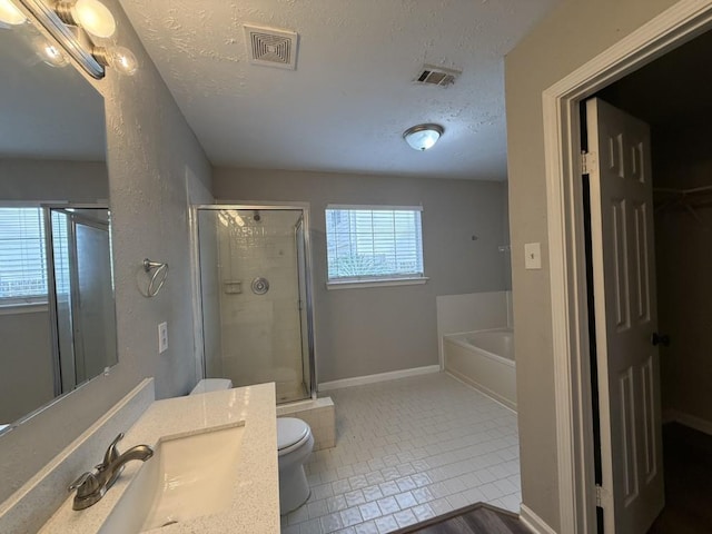 full bathroom featuring shower with separate bathtub, tile patterned floors, toilet, and a textured ceiling