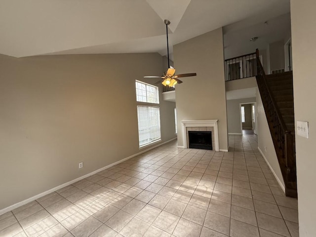 unfurnished living room featuring light tile patterned flooring, high vaulted ceiling, ceiling fan, and a fireplace