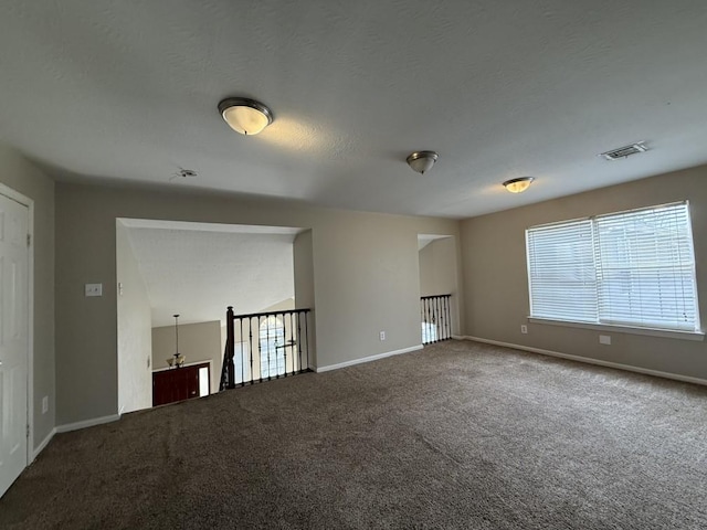 carpeted spare room with a textured ceiling