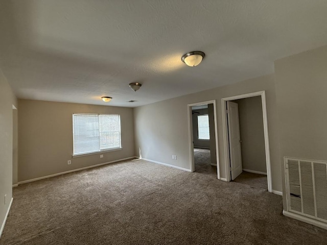 empty room with carpet flooring and a textured ceiling