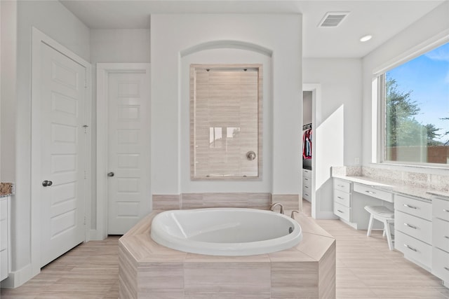 bathroom featuring tile patterned floors and a relaxing tiled tub