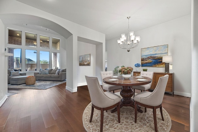 dining space featuring dark hardwood / wood-style flooring and a notable chandelier