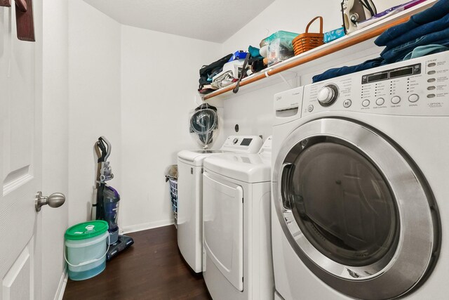 laundry area with washer and dryer and dark hardwood / wood-style flooring