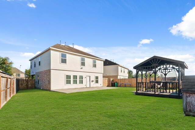 rear view of house with a gazebo, a patio, a wooden deck, and a lawn