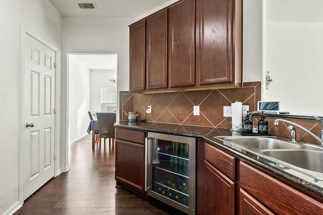 kitchen featuring dark stone counters, sink, wine cooler, decorative backsplash, and dark hardwood / wood-style flooring