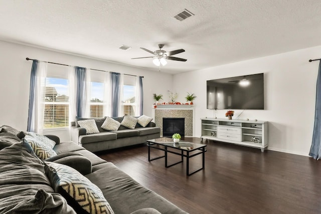 living room with ceiling fan, dark hardwood / wood-style flooring, and a textured ceiling