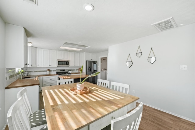 dining room featuring sink and wood-type flooring