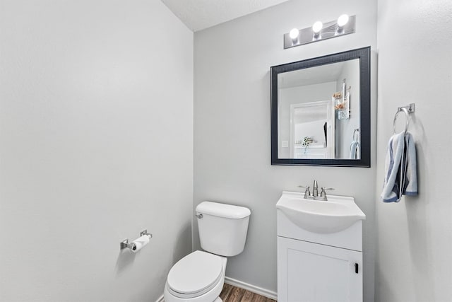 bathroom featuring vanity, a textured ceiling, hardwood / wood-style flooring, and toilet