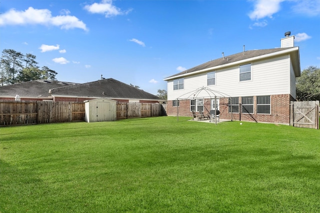 rear view of property featuring a yard, a patio, a shed, and a gazebo