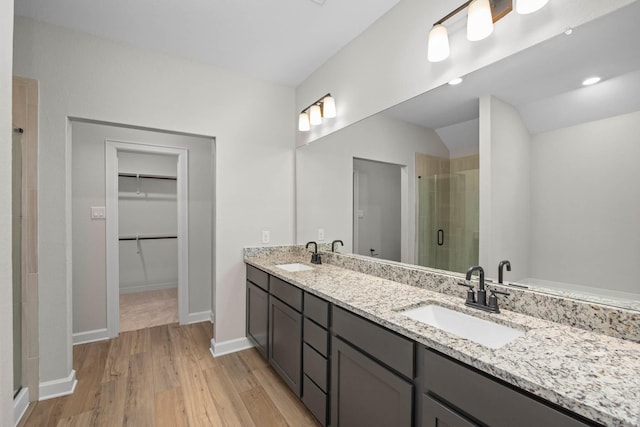 bathroom featuring hardwood / wood-style floors, vanity, and an enclosed shower