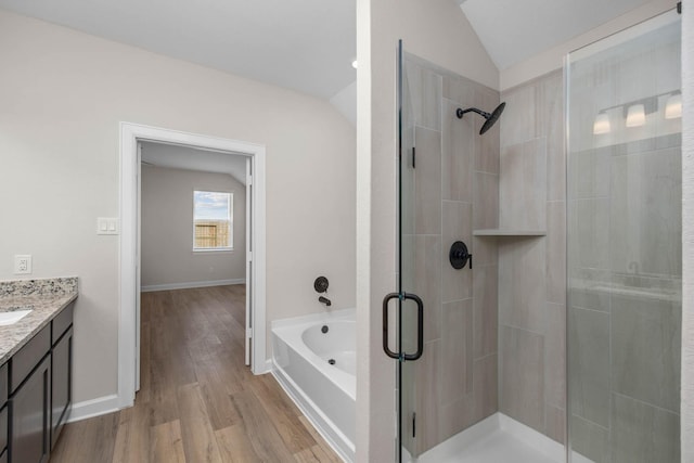 bathroom featuring wood-type flooring, vanity, separate shower and tub, and lofted ceiling