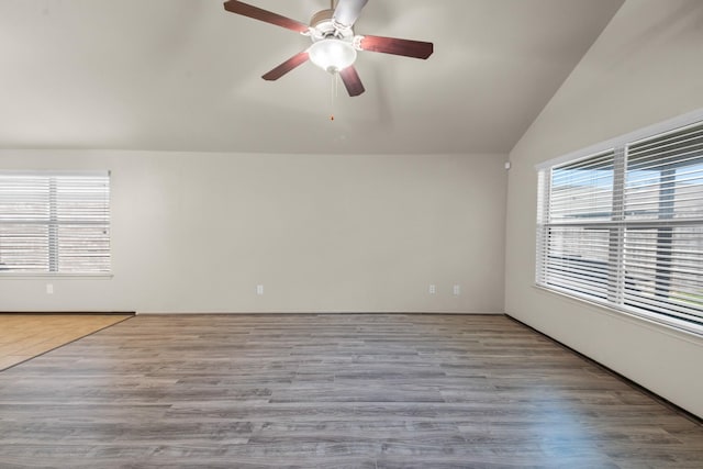 empty room featuring ceiling fan, light wood-type flooring, and vaulted ceiling