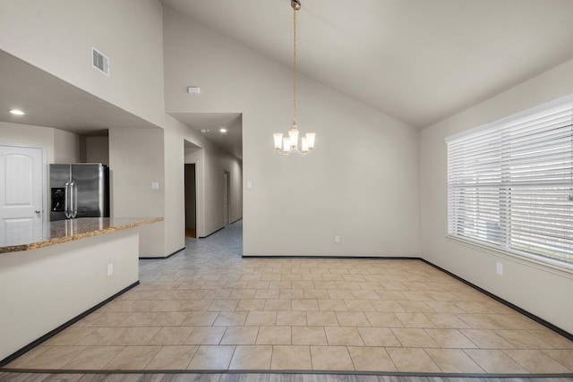 interior space with light tile patterned floors, high vaulted ceiling, and a notable chandelier