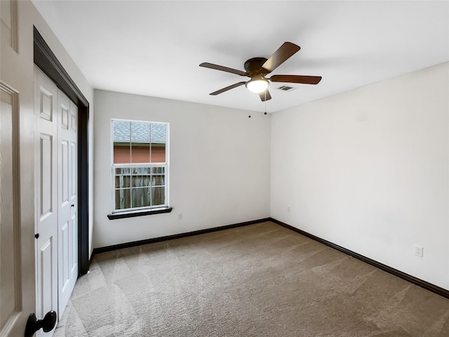 unfurnished bedroom with ceiling fan, light carpet, and a closet