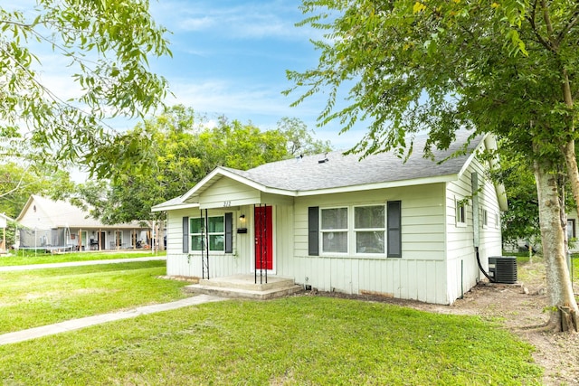 view of front of property featuring central air condition unit and a front lawn