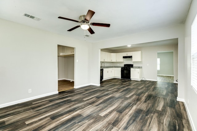 unfurnished living room with ceiling fan, sink, and dark wood-type flooring