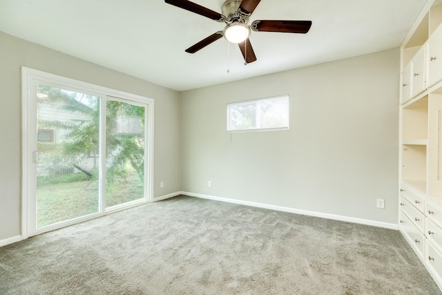 spare room with ceiling fan, light colored carpet, and a wealth of natural light