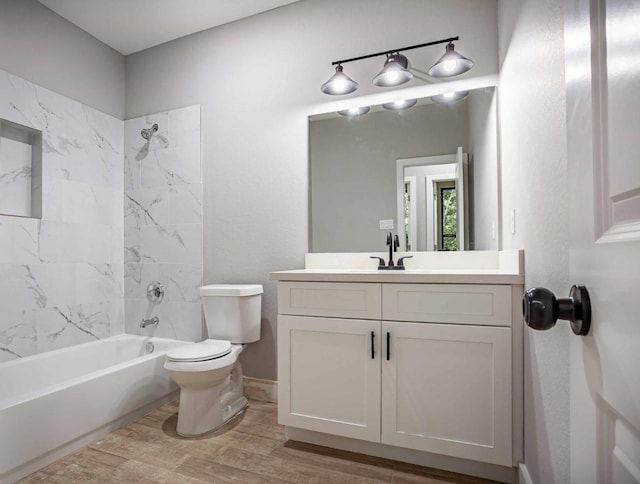 full bathroom featuring vanity, tiled shower / bath combo, and toilet