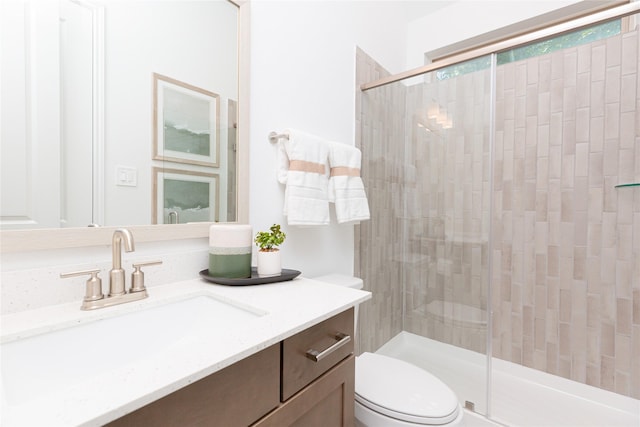 bathroom featuring an enclosed shower, vanity, and toilet