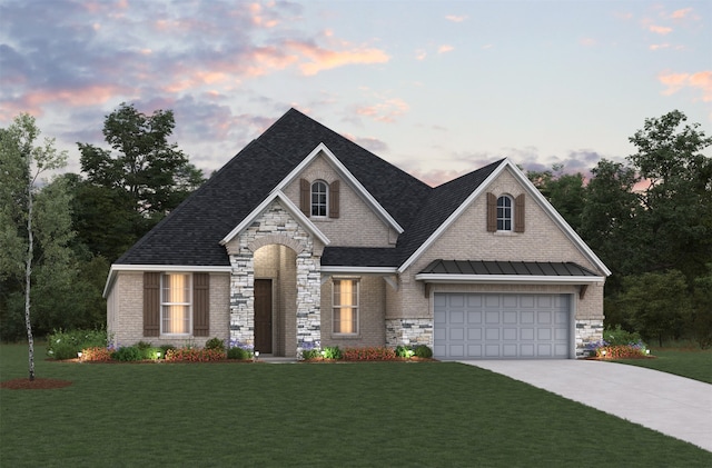 view of front of home featuring a garage and a lawn