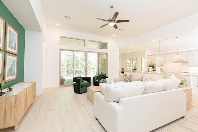 living room with light hardwood / wood-style flooring and ceiling fan