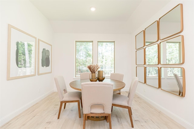 dining room featuring light hardwood / wood-style floors and lofted ceiling